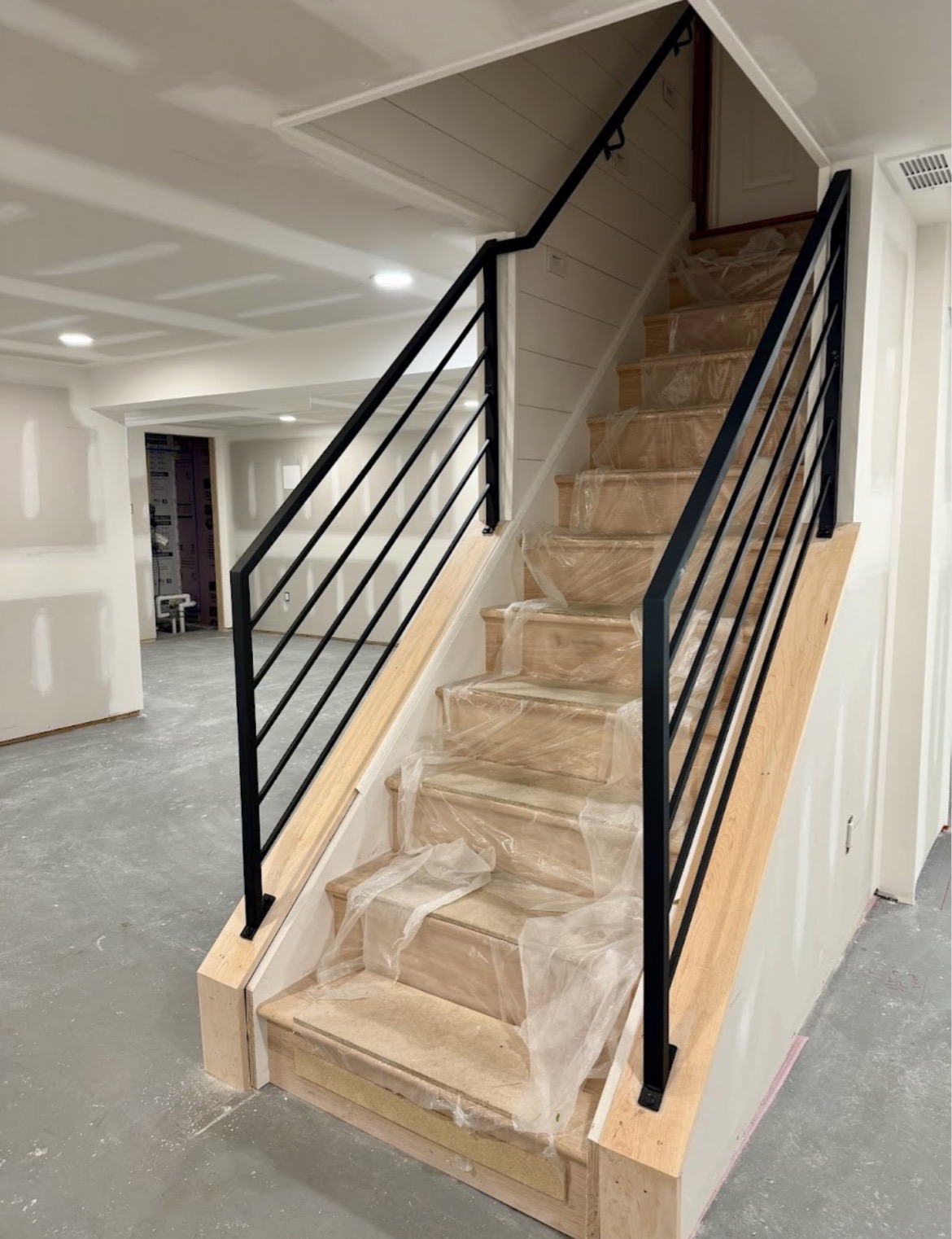 Finished basement with modern staircase and railing